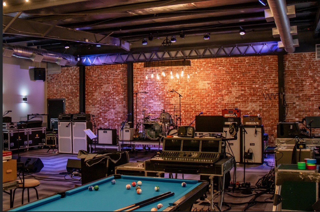 Rehearsal Space with band equipment and a pool table.